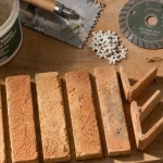 Brique pour mur intérieur : plaquettes de parement posées, mortier et truelle